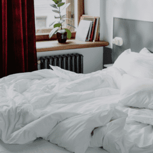 habiacion con cama con ropa blanca desteñida