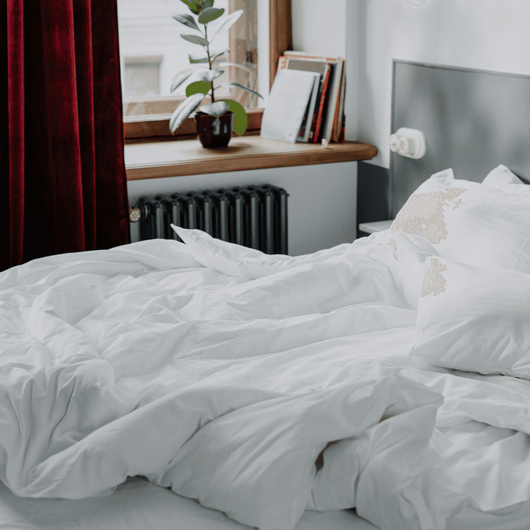 habiacion con cama con ropa blanca desteñida